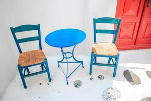 blauw stoelen en tafel Aan straat van typisch Grieks traditioneel dorp met wit huizen Aan Mykonos eiland, Griekenland, Europa foto