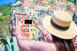 jong vrouw nemen een foto van mooi visie Bij oud dorp in cinque terrein, ligurië, Italië. Europese Italiaans vakantie.