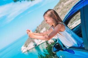 weinig meisje Aan vakantie reizen door auto. zomer vakantie en auto reizen concept foto