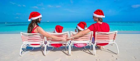 terug visie van familie in Kerstmis hoeden hebben pret Aan tropisch strand foto