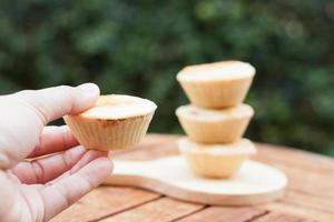 vrouw hand met mini cheesecakes foto