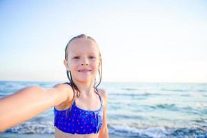 aanbiddelijk weinig meisje nemen selfie Bij tropisch strand Aan exotisch eiland gedurende zomer vakantie foto