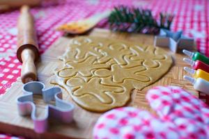 snijdend peperkoek koekje deeg voor Kerstmis foto