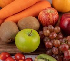 verlies van appels, druiven, wortelen en sinaasappels samen foto