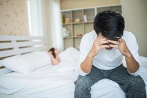 boos man op het bed na ruzie met zijn vriendin foto