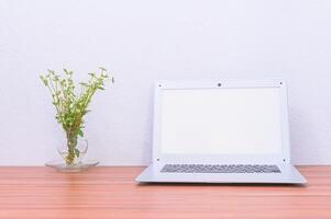 laptop en bloem op het bureau foto