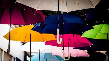 straat versierd met gekleurde parasols. veel paraplu's kleuren de lucht in de stad foto