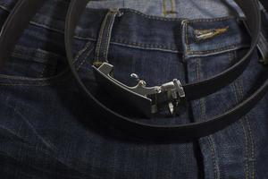 detail van jeans met zwart lederen riem close-up. foto