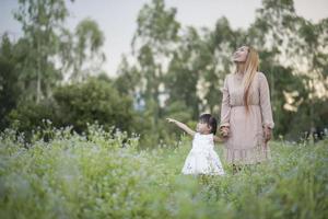 moeder en dochtertje spelen samen in een weiland foto