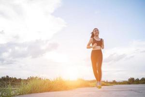 een jonge gelukkige vrouwelijke atleet die buitenshuis jogt