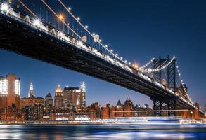 Manhattan horizon en Manhattan brug Bij nacht foto