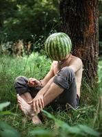 jongen met een watermeloen in plaats daarvan van hoofd foto