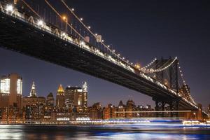 Manhattan horizon en Manhattan brug Bij nacht foto