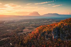 zonsondergang over bergketen met kleurrijk herfstbos op heuvel op het platteland foto