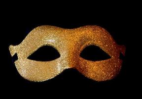 carnaval symbool masker in goud kleur Aan zwart achtergrond foto