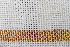 texturen van weefgetouw geweven draden in wit tonen met gouden randen foto