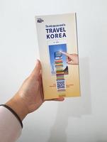 Jakarta, Indonesië in mei 2022. een hand- is Holding een Welkom gids boek voor reizigers Aan vakantie Aan Korea foto