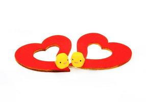 twee geel eend speelgoed en rood hart geïsoleerd Aan wit achtergrond. Valentijn dag en paar lief concept. geselecteerd focus Bij eend. foto