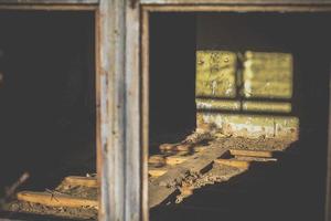 dichtbij omhoog zonlicht door gebroken venster Aan muur met vlokkig groen verf concept foto