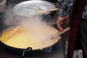 rango, Italië - december 8, 2017 - mensen Koken polenta traditioneel maïs tarwe maaltijd foto