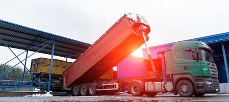 een vrachtauto lost producten Bij de fabriek Bij dageraad foto