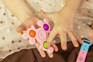knal het is een veelkleurig anti stress speelgoed- in kinderen handen. bubbel spel. anti stress speelgoed. foto