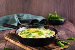 omelet met spinazie en kaas in een pan Aan de tafel. ketogeen eetpatroon. foto