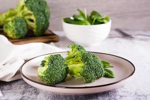vers broccoli verdeeld in bloeiwijzen Aan een bord Aan de tafel. groente eetpatroon. foto