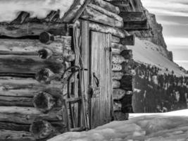 sneeuw slee buiten houten log cabine hut in winter foto