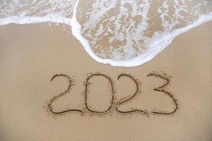 2023 jaar geschreven Aan zanderig strand zee. top visie. vlak leggen. foto