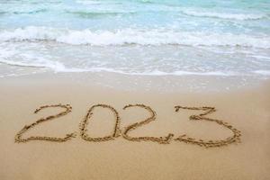 2023 jaar geschreven Aan zanderig strand zee. foto