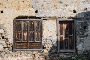 oud houten deuren en luiken Aan de muur van een verlaten huis, de concept van achtergrond en decor, de idee van toerisme en reizen geschiedenis studie foto