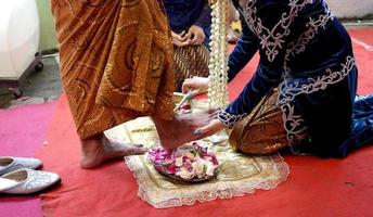 bruid wast bruidegom voeten in traditioneel bruiloft ceremonie foto