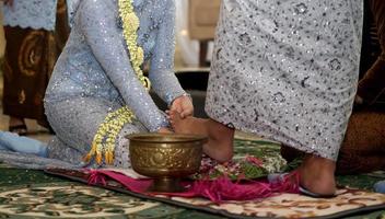 bruid wast bruidegom voeten in traditioneel bruiloft ceremonie in Indonesië foto