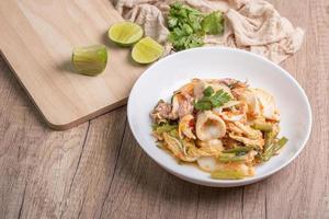 sukiyaki gedroogde inktvis Thais eten in witte kom op houten achtergrond foto