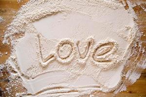 Valentijnsdag dag. de woord liefde is geschreven in meel, Aan een hout textuur. kopiëren ruimte. conceptueel. foto