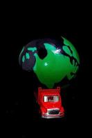 miniatuur vrachtauto draag- een wereldbol foto