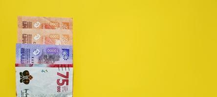 nieuw Indonesisch bankbiljetten geïsoleerd Aan geel achtergrond. foto