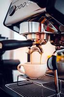 koffie extractie van de koffie machine met een filterhouder gieten koffie in een kopje, espresso poreus van koffie machine Bij koffie winkel foto