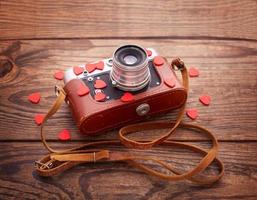 retro camera met rood harten Aan houten achtergrond. foto