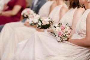 dichtbij omhoog van naakt bruidsmeisjes jurken, bloem boeketten, modern en modieus jurken zittend Aan bruiloft ceremonie. bruiloft dag. hoog kwaliteit foto