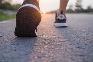 loper atleet voeten rennen Aan weg. vrouw geschiktheid silhouet zonsopkomst joggen training welzijn concept. foto