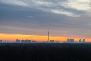 vroeg winter dageraad over- Woud en stad Aan horizon foto