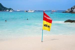 rood en geel vlag tonen kennisgeving voor zwemmen in de zee foto