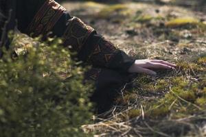 dichtbij omhoog vrouw hand- in etnisch kleren aanraken gras concept foto