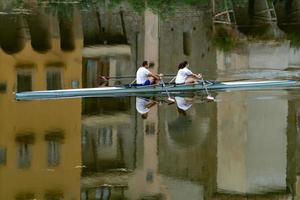 Florence, Italië - september 1 2018 - mensen roeien in stad- rivier- met oud huizen reflectie foto