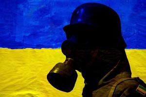 Oekraïne soldaat silhouet vervelend gas- masker Aan blauw en geel vlag foto