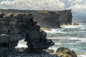 pico eiland golven Aan lava kliffen foto