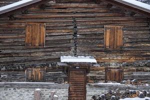 hout log cabine hut gedekt door sneeuw in dolomieten foto