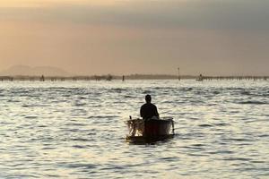 visser silhouet Bij zonsondergang in Venetië lagune chioggia haven van een boot foto